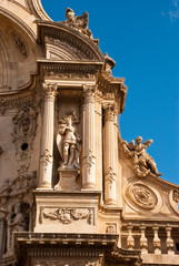 Fototapeta na wymiar Part of facade of catholic cathedral with statue in Murcia, Spain.Architecture of baroque and renaissance style.
