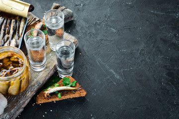 Sandwich with sprats and vodka. Sprat in oil. On a black background. top view. Free copy space.