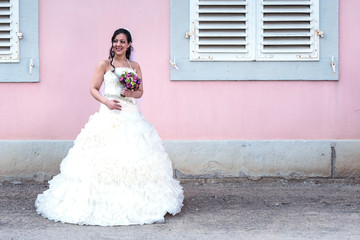 Die frisch gebackene Braut hält ihren Hochzeitsstrauß in der Hand und lächelt