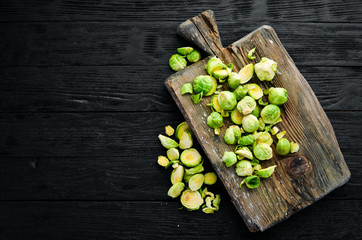 Fresh Brussels cabbage on a black background. Vegetables. Top view. Free space for your text.