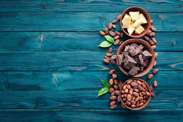Chocolate, cocoa and cocoa beans on a blue wooden background. Top view. Free copy space.