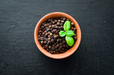 Black pepper peas. Spices Top view. On the old background.