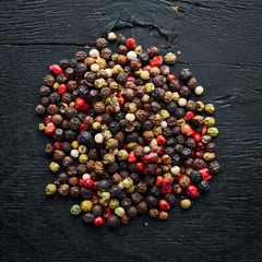 Red and black pepper on a wooden background. Spices Top view. Free space for your text.