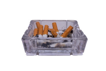 Glass ashtray with cigarettes on a white isolated background