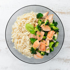Risotto with chicken fillet and vegetables. Top view. On a white wooden background. Free copy space.