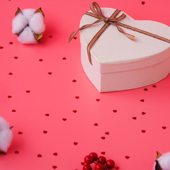 St. Valentine day background. Gift box with gold ribbon and lights on a pink background. Holiday background