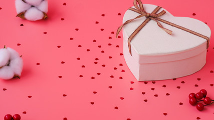 St. Valentine day background. Gift box with gold ribbon and lights on a pink background. Holiday background.