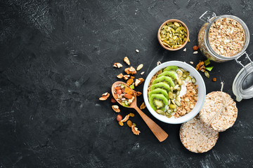 Oatmeal with kiwi and pumpkin seeds. Top view. Free space for your text.