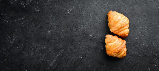 Croissants on a black background. Top view. Free space for your text.