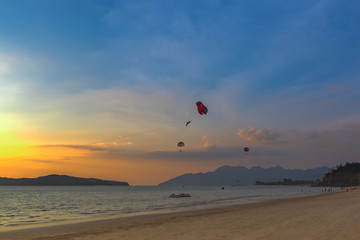 Seascape with parasailing. Sunset on the beach of Langkawi Island, Malaysia.