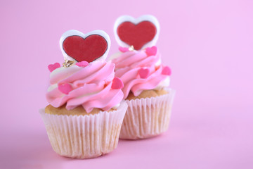 Cupcakes with hearts on pink background