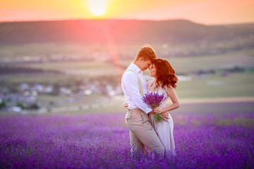 Fototapeta na wymiar a loving couple standing in a lavender field looking at a pink cloud in the shape of a heart