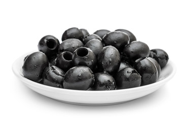 Saucer with black olives on white.