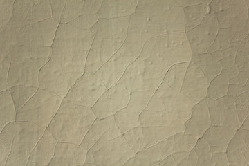 old white wall with cracks in the paint. rough surface texture