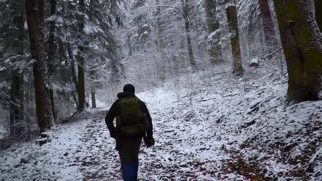 young man with backpack doing hiking in snowy and foggy forest / yenice forest karabuk in turkey