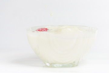 Obraz na płótnie Canvas Splashes into a cup of milk with strawberries.