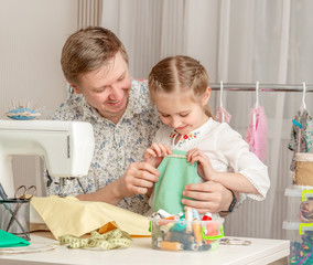little girl and her dad in a sewing workshop