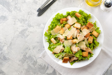 Caesar salad with chicken and herbs on the table, Caesar sauce, Parmesan cheese