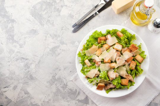 Caesar salad with chicken and herbs on the table, Caesar sauce, Parmesan cheese