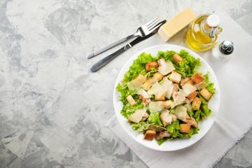 Caesar salad with chicken and herbs on the table, Caesar sauce, Parmesan cheese - obrazy, fototapety, plakaty