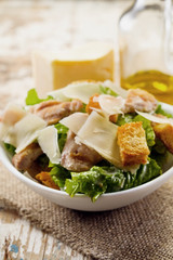 Caesar salad with chicken and herbs on the table, Caesar sauce, Parmesan cheese