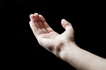 man's hand on a black background shows something