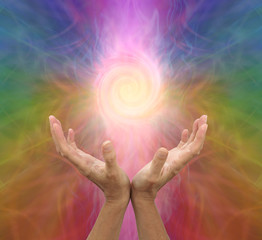 Channeling rainbow coloured  vortex healing energy  - female hands held open and palms upwards with...