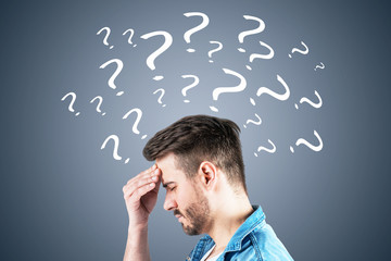 Stressed man in jeans shirt, question marks, gray