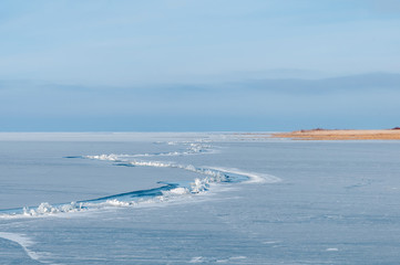 broken ice on a frozen lake against a blue sky