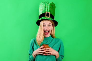 Saint Patrick's Day. Happy girl in green top hat holds pot with gold. Leprechaun. Irish Traditions....