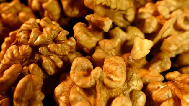 Walnut closeup. Nuts without shell on a black background. Kernels scattered on the table.