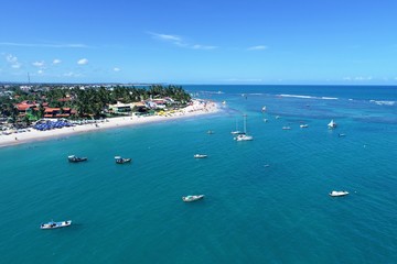 Aerial view of Porto de Galinhas beaches, Pernambuco, Brazil: unique experience of swimming with fishs in natural pools.  Beautiful landscape. Candles, sailboats, rafts, boats in the harbor!