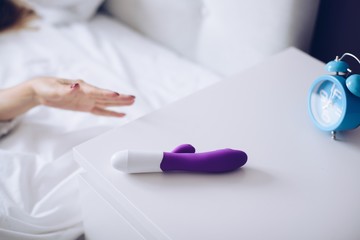 Young woman holding sex toy dildo vibrator