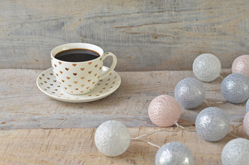 Fototapeta na wymiar Cup in a hearts on a wooden background. Cup of coffee. Cotton balls lights on a wooden background
