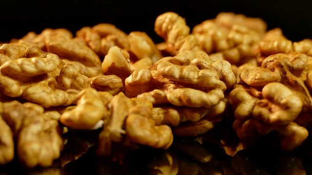 Walnut closeup. Nuts without shell on a black background. Kernels scattered on the table.