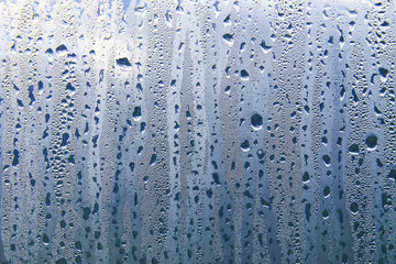 Texture of rain drops on a glass wet transparent surface.
