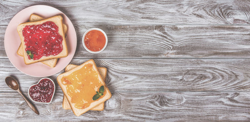 Delicious toasts with various sweet jams on grey background. Copyspace for your text, banner.