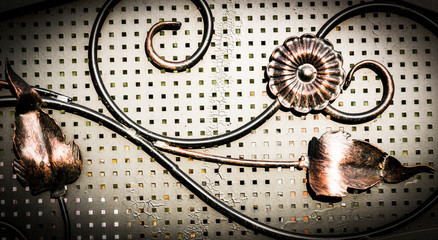 Details, structure and ornaments of forged iron gate. Decorative ornamen with roses, made from metal