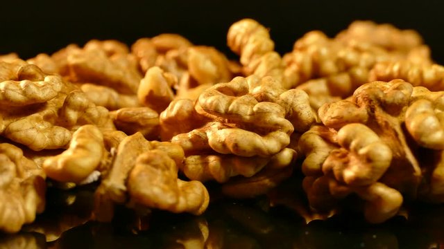 Walnut closeup. Nuts without shell on a black background. Kernels scattered on the table.