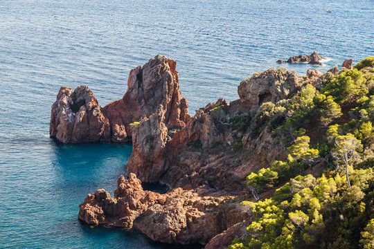 Red cliffs, rocky coast of Esterel massif (St.Raphael - Agay), sunset sky. Cote d'Azur, French Riviera. Holidays in France.