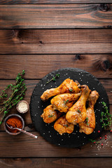 Grilled chicken legs on wooden background. Top view
