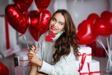 Attractive young woman with gifts and balloons