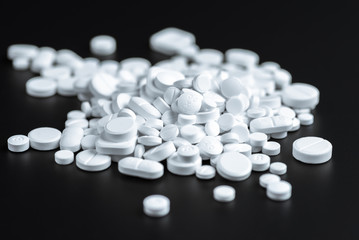 White pills or capsules on a black background
