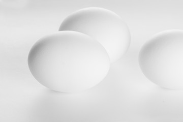 Three  white eggs on white background