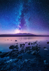 Colorful milky way galaxy over the lake and mountain. Beautiful night landscape.