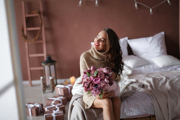 smiling woman in pajama holding gift box and looking at the camera, valentines day concept