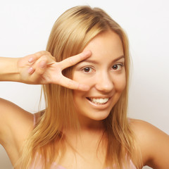 smiling beautiful young woman showing two fingers or victory gesture