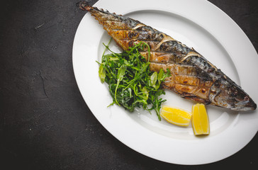 Grilled mackerel fillets with lemon on black board