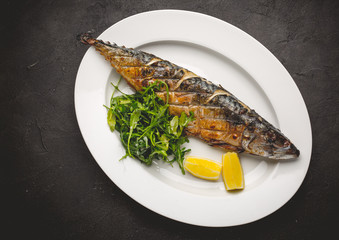 Grilled mackerel fillets with lemon on black board