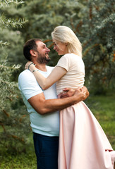 Happy  man holding his wife in his arms in the sea buckthorn garden